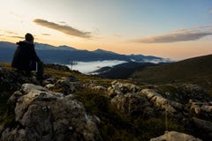 Person in Black Hoodie Sitting on Gray Stone Royalty Free Stock Photography Person in Black Hoodie Sitting on Gray Stone Royalty Free Stock Photography