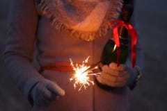 Person with bottle of champagne and sparkler Person with bottle of champagne and sparkler