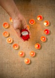 Person holding golden ring in box against heart made of candles. Conceptual photo of person holding golden ring in box against heart made of candles Royalty Free Stock Images Person holding golden ring in box against heart made of candles. Conceptual photo of person holding golden ring in box against heart made of candles Royalty Free Stock Images