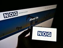 Person holding mobile phone with logo of American oil company Northern Oil and Gas Inc. (NOG) on screen with web page.