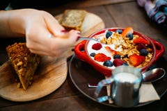 Person Holding Spoon and Round Red Ceramic Bowl With Pastries Stock Image Person Holding Spoon and Round Red Ceramic Bowl With Pastries Stock Image