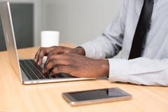 Person Wearing White Dress Shirt and Black Necktie Using Macbook Air on Beige Wooden Table Stock Images Person Wearing White Dress Shirt and Black Necktie Using Macbook Air on Beige Wooden Table Stock Images