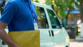 Persona en el sobre con los documentos, entrega de la oficina, servicio de la tenencia del uniforme imágenes de archivo libres de regalías Persona en el sobre con los documentos, entrega de la oficina, servicio de la tenencia del uniforme imágenes de archivo libres de regalías