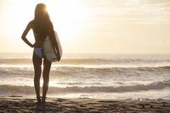 Persona que practica surf del bikiní de la mujer y playa de la puesta del sol de la tabla hawaiana imágenes de archivo libres de regalías Persona que practica surf del bikiní de la mujer y playa de la puesta del sol de la tabla hawaiana imágenes de archivo libres de regalías