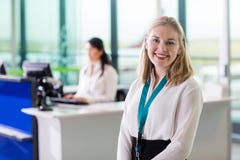 Personal de tierra joven que sonríe mientras que colega que trabaja en el aeropuerto con referencia a imagen de archivo libre de regalías Personal de tierra joven que sonríe mientras que colega que trabaja en el aeropuerto con referencia a imagen de archivo libre de regalías