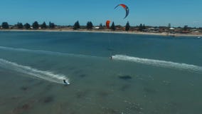 Personas que practica surf profesionales kiteboarding en el océano azul claro en paisaje marino tropical del día soleado en la op almacen de metraje de vídeo Personas que practica surf profesionales kiteboarding en el océano azul claro en paisaje marino tropical del día soleado en la op almacen de metraje de vídeo
