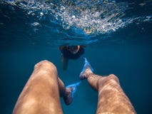 Perspectiva pessoal de uma natação masculina para trás subaquática Jovem mulher que segue seu noivo foto de stock Perspectiva pessoal de uma natação masculina para trás subaquática Jovem mulher que segue seu noivo foto de stock