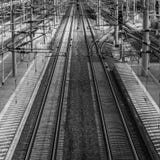 Perspektivenansicht von Eisenbahnlinien mit obenliegenden Linien nahe bei einer Plattform lizenzfreies stockfoto Perspektivenansicht von Eisenbahnlinien mit obenliegenden Linien nahe bei einer Plattform lizenzfreies stockfoto
