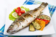 Peschi, branzino grigliato con il limone e verdure grigliate immagine stock Peschi, branzino grigliato con il limone e verdure grigliate immagine stock