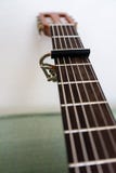 Pescoço da guitarra com fim da opinião de baixo ângulo do capo acima Imagens de Stock Royalty Free Pescoço da guitarra com fim da opinião de baixo ângulo do capo acima Imagens de Stock Royalty Free