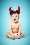 Petit bébé drôle avec des klaxons de diable Photos stock Petit bébé drôle avec des klaxons de diable Photos stock