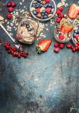 Petit déjeuner dans des pots Farine d'avoine avec des fraises et d'autres baies, écrous et graines frais sur le fond rustique, vu Photos libres de droits Petit déjeuner dans des pots Farine d'avoine avec des fraises et d'autres baies, écrous et graines frais sur le fond rustique, vu Photos libres de droits