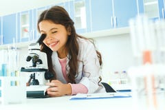 Petit enfant avec apprendre la classe dans le laboratoire d'école utilisant le microscope photographie stock Petit enfant avec apprendre la classe dans le laboratoire d'école utilisant le microscope photographie stock