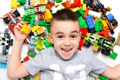 Petit enfant jouant avec un bon nombre de jouets en plastique colorés d'intérieur images stock Petit enfant jouant avec un bon nombre de jouets en plastique colorés d'intérieur images stock