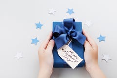 Petit fils tenant un cadeau ou une boîte actuelle avec l'étiquette heureuse de salutation de jour de pères image stock Petit fils tenant un cadeau ou une boîte actuelle avec l'étiquette heureuse de salutation de jour de pères image stock