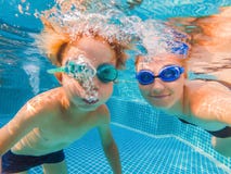 Petit garçon apprenant à nager dans une piscine, mère tenant l'enfant photos stock Petit garçon apprenant à nager dans une piscine, mère tenant l'enfant photos stock