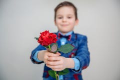 Petit garçon dans la position de costume avec la rose rouge, d'isolement sur un fond clair image stock Petit garçon dans la position de costume avec la rose rouge, d'isolement sur un fond clair image stock