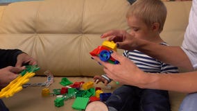 Petit garçon et ses parents jouant avec la construction réglée à la maison ensemble tir 4k clips vidéos Petit garçon et ses parents jouant avec la construction réglée à la maison ensemble tir 4k clips vidéos