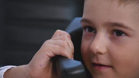 Petit garçon parlant du téléphone dans le bureau Fin vers le haut image libre de droits Petit garçon parlant du téléphone dans le bureau Fin vers le haut image libre de droits