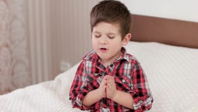 Petit garçon priant, enfant disant la prière avant d'aller au lit, croyance forte au coeur, garçon priant à un dieu Petit garçon priant, enfant disant la prière avant d'aller au lit, croyance forte au coeur, garçon priant à un dieu