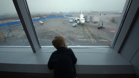 Petit garçon regardant la fenêtre l'aéroport banque de vidéos Petit garçon regardant la fenêtre l'aéroport banque de vidéos