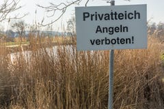 Petit lac avec le signe “étang privé - pêche d'interdiction interdite “dans la langue allemande photographie stock libre de droits Petit lac avec le signe “étang privé - pêche d'interdiction interdite “dans la langue allemande photographie stock libre de droits