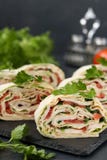 Petit pain de Lavash avec le poulet fumé, les tomates, le fromage et les verts situés sur un fond foncé photos stock Petit pain de Lavash avec le poulet fumé, les tomates, le fromage et les verts situés sur un fond foncé photos stock