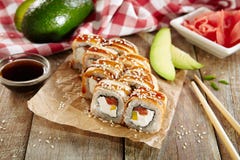Petit pain de sushi saumoné et fumé d'anguille avec Daikon mariné image libre de droits Petit pain de sushi saumoné et fumé d'anguille avec Daikon mariné image libre de droits