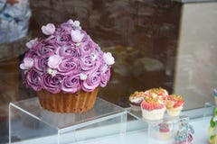 Petit pain rose géant sur l'affichage grand produit de confiserie pour attirer des clients à la pâtisserie décorations de sucre photos stock Petit pain rose géant sur l'affichage grand produit de confiserie pour attirer des clients à la pâtisserie décorations de sucre photos stock