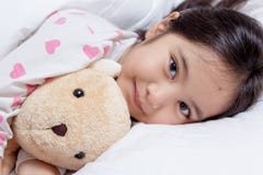 Petit sommeil asiatique adorable de fille avec la poupée d'ours photo stock Petit sommeil asiatique adorable de fille avec la poupée d'ours photo stock