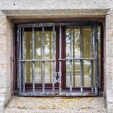 Petite fenêtre du sous-sol derrière les barres photo stock Petite fenêtre du sous-sol derrière les barres photo stock