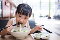 Petite fille chinoise asiatique mangeant de la soupe de nouilles de boeuf Photos stock Petite fille chinoise asiatique mangeant de la soupe de nouilles de boeuf Photos stock
