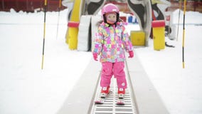 Petite fille dans l'équipement d'hiver restant sur Ski Conveyor L'enfant a l'amusement commence à skier Une expérience heureuse d banque de vidéos Petite fille dans l'équipement d'hiver restant sur Ski Conveyor L'enfant a l'amusement commence à skier Une expérience heureuse d banque de vidéos