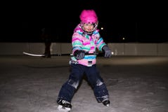 Petite fille dans le rose dans la vitesse d'hockey photographie stock Petite fille dans le rose dans la vitesse d'hockey photographie stock