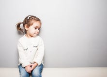 Petite fille de sourire mignonne sur le fond gris images stock Petite fille de sourire mignonne sur le fond gris images stock