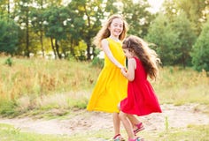 Petite fille deux heureuse embrassant et dansant au jour d'été ensoleillé Photographie stock Petite fille deux heureuse embrassant et dansant au jour d'été ensoleillé Photographie stock