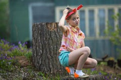 Petite fille perplexe s'asseyant près de la maison de ferme nature Photo libre de droits Petite fille perplexe s'asseyant près de la maison de ferme nature Photo libre de droits