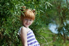 Petite fille rousse mignonne posant près de l'arbre photos stock Petite fille rousse mignonne posant près de l'arbre photos stock