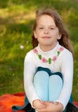 Petite fille s'asseyant sur une pelouse Images libres de droits Petite fille s'asseyant sur une pelouse Images libres de droits