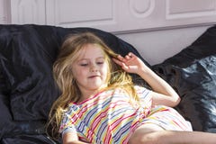 Petite fille se situant dans le lit à la maison photographie stock libre de droits Petite fille se situant dans le lit à la maison photographie stock libre de droits