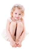 Petite fille souriante s'asseyant sur le blanc images stock Petite fille souriante s'asseyant sur le blanc images stock