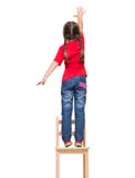 Petite fille utilisant le T-shirt rouge et atteignant à l'extérieur quelque chose vers le haut salut photo stock Petite fille utilisant le T-shirt rouge et atteignant à l'extérieur quelque chose vers le haut salut photo stock