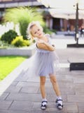 Petite jolie position européenne de fille dans la cour et la robe grise de port photos stock Petite jolie position européenne de fille dans la cour et la robe grise de port photos stock