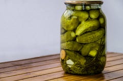 Petits concombres marinés dans un pot sur un fond en bois images stock Petits concombres marinés dans un pot sur un fond en bois images stock