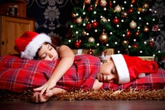 Petits enfants de mêmes parents endormis tout en attendant des cadeaux photographie stock Petits enfants de mêmes parents endormis tout en attendant des cadeaux photographie stock