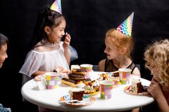 Petits enfants heureux ayant l'amusement avec le gâteau pendant la partie images stock Petits enfants heureux ayant l'amusement avec le gâteau pendant la partie images stock