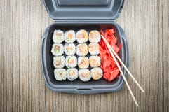 Petits pains de sushi dans un conteneur sur une table en bois Vue supérieure images libres de droits Petits pains de sushi dans un conteneur sur une table en bois Vue supérieure images libres de droits