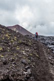 Petropavlovsk-Kamchatsky region, Russia - August 11, 2013: Tourist going up on a lava field near Tolbachik Volcano stock photography Petropavlovsk-Kamchatsky region, Russia - August 11, 2013: Tourist going up on a lava field near Tolbachik Volcano stock photography