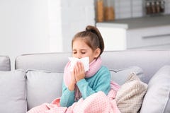 Peu douleur de fille de toux et froid sur le sofa image libre de droits Peu douleur de fille de toux et froid sur le sofa image libre de droits