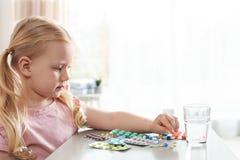 Peu enfant avec beaucoup de différentes pilules à la table Danger d'intoxication de m?dicament photos libres de droits Peu enfant avec beaucoup de différentes pilules à la table Danger d'intoxication de m?dicament photos libres de droits